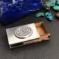 A silver business card holder with a tarot card on it.