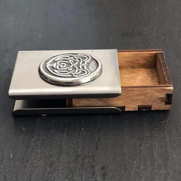 A silver business card holder with a wooden coin in it. A silver business card holder with a wooden coin in it.