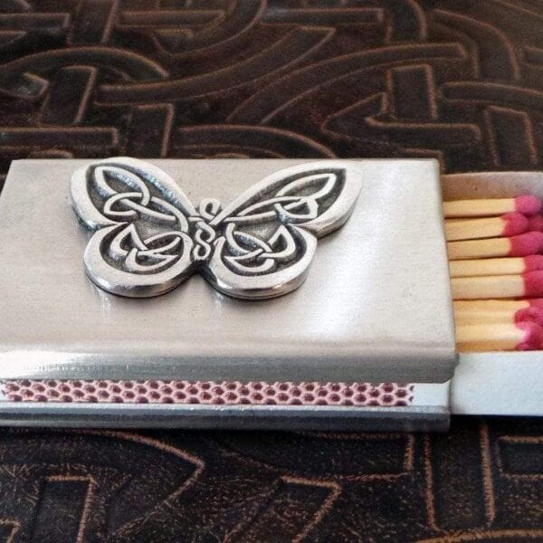 A matchbox with a butterfly on it.