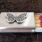 A matchbox with a butterfly on it.