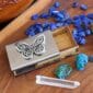 A wooden box with a butterfly and crystals on it.