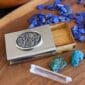 A business card holder with a blue stone and crystals.