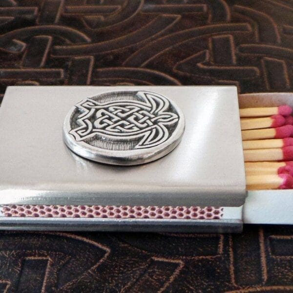 A matchbox with a celtic design on it.