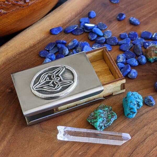 A business card holder with stones and crystals on a wooden table.