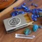 A business card holder with stones and crystals on a wooden table.