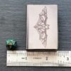 A metal case with a dice and a ruler next to it.
