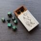 A set of green dice and a wooden box.