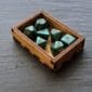 A set of green dice in a wooden box.