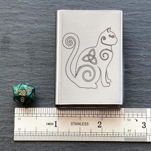 A celtic cat on a ruler next to a dice.
