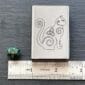 A celtic cat on a ruler next to a dice.