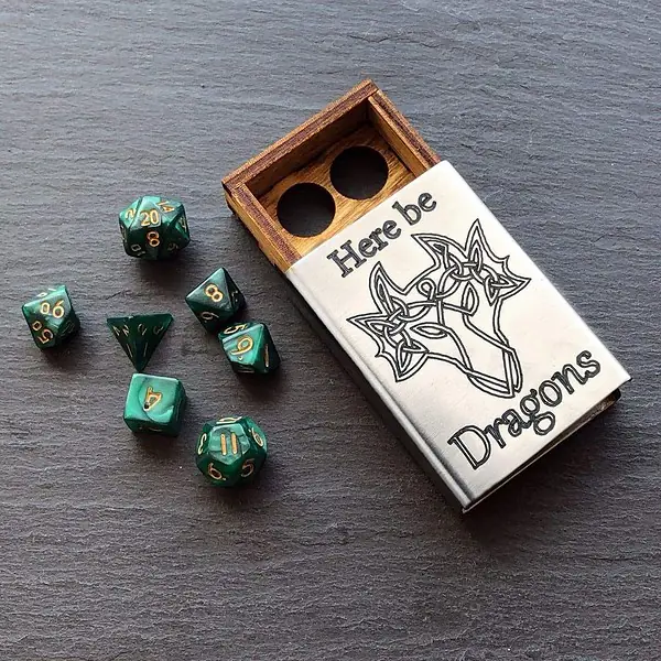 A set of dice in a wooden box with a dragon on it.