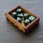 A set of green dice in a wooden box.