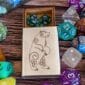 A wooden box with dice and a bear on it.