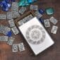 A metal box with stones and a celtic design on it.