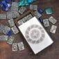 A metal box with stones and a celtic design on it.