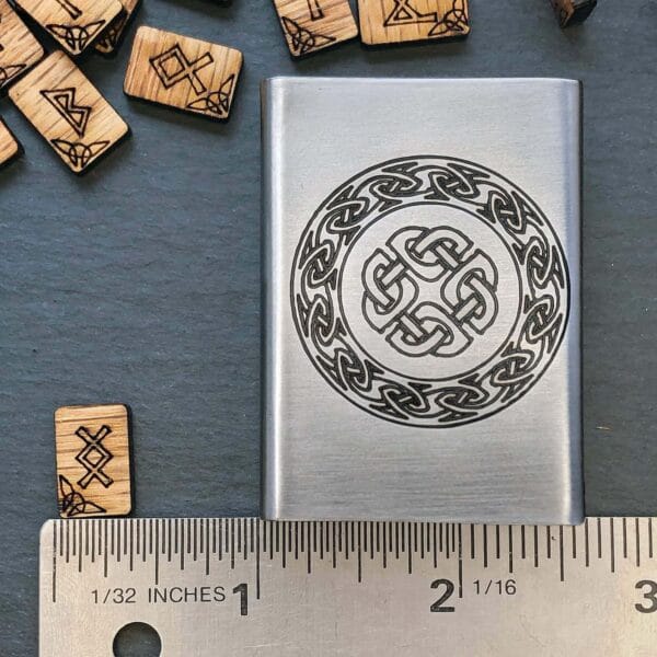 A wooden flask with a celtic design on it.