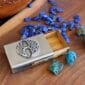 A business card holder with a celtic design and blue stones.