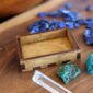 A wooden box with blue stones and a quartz crystal.