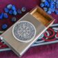 A metal box with blue stones and a viking compass.