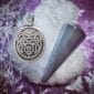 A silver pendant with a bear on it.