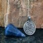 A celtic eagle pendant on a blue stone.