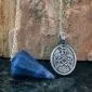 A celtic eagle pendant on a blue stone.