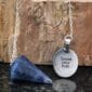 A necklace with a blue stone and a pendant that says speak your truth.