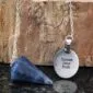 A necklace with a blue stone and a pendant that says speak your truth.