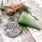 A celtic tree of life pendant with a cone and pine needles.