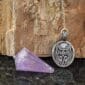 A purple amethyst talisman with a wolf on it.