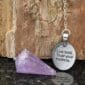 A purple amethyst pendant with the words live bold trust your intentions.