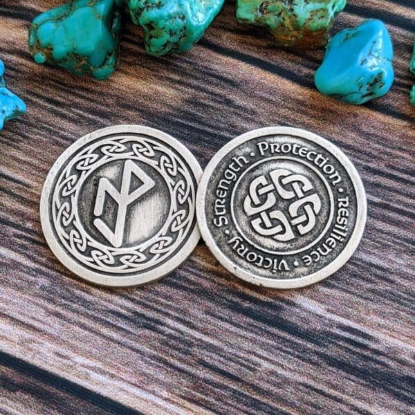 A silver coin with a celtic symbol on it.