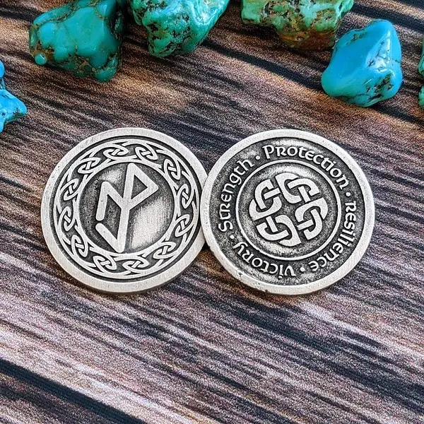 A silver coin with a celtic symbol on it. A silver coin with a celtic symbol on it.
