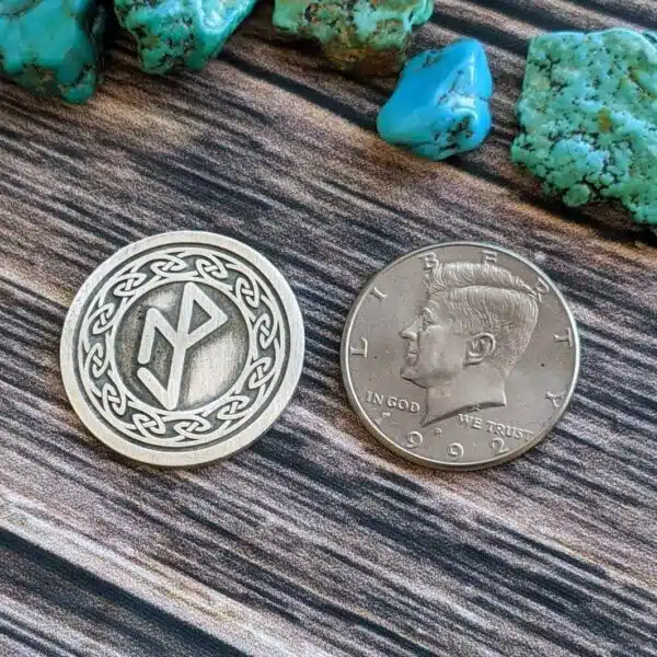 A coin with a celtic design and turquoise stones. A coin with a celtic design and turquoise stones.
