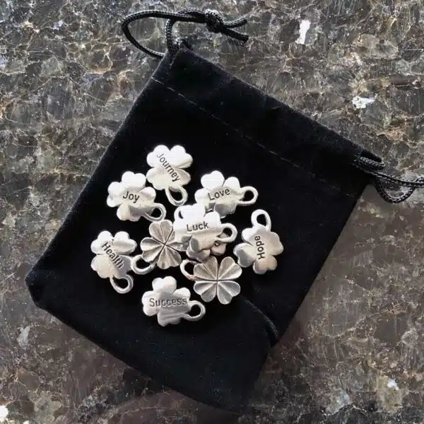 Shamrock charms in a pouch on a table. Shamrock charms in a pouch on a table.