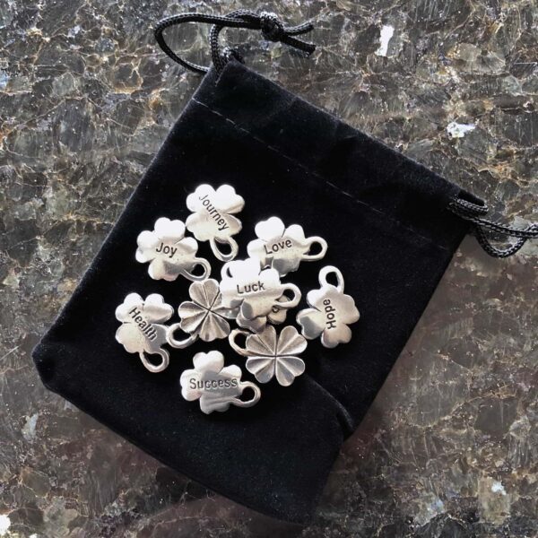 Shamrock charms in a pouch on a table. Shamrock charms in a pouch on a table.