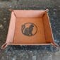A leather tray with a cat on it.