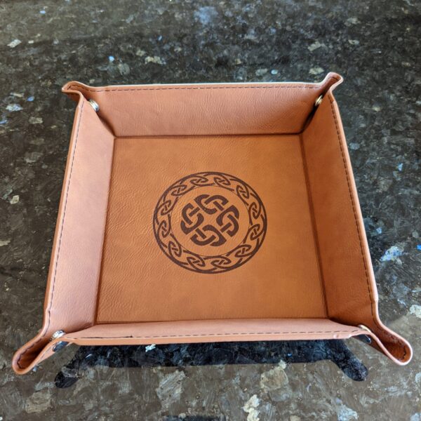 A leather tray with a celtic design on it.