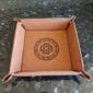 A leather tray with a celtic design on it.