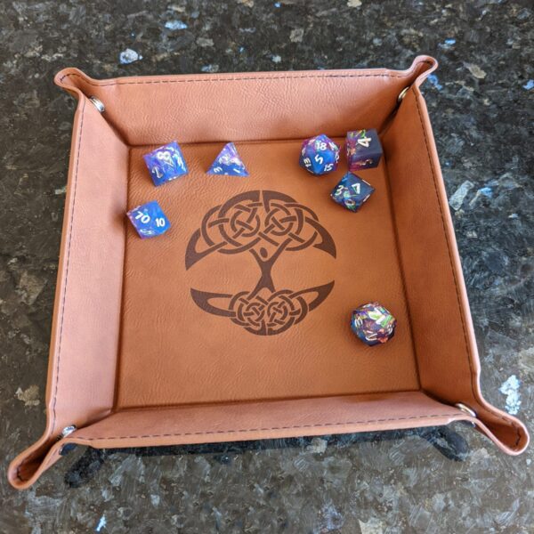 A leather tray with a set of dice on it.
