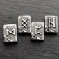 Four silver pendants with viking symbols on them.
