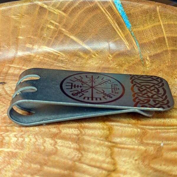 Viking money clip on a wooden plate.