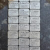 A group of Gather Rune Set 24pc Elder Futhark Pewter with different names on them.