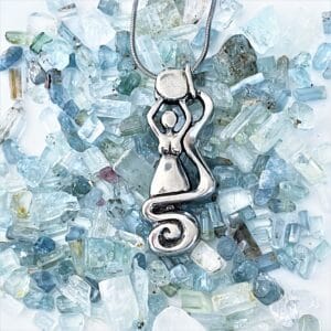 A Water Elemental Necklace with a woman sitting on top of crystals.