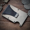 The Celtic Bear Titanium Minimalist Wallet and a key chain on a table.