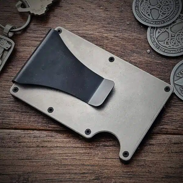 Celtic Bear Titanium Minimalist Wallet The Celtic Bear Titanium Minimalist Wallet and a key chain on a table.