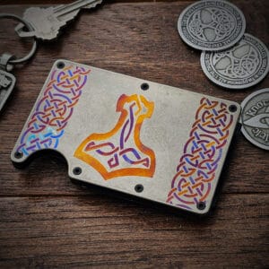 A Thor's Hammer Titanium Minimalist Wallet and a keychain with a design on it.
