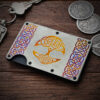 A Tree of Life Titanium Minimalist Wallet on a wood surface.