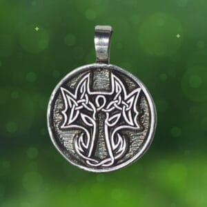 A silver pendant named "The Lady and the Dragon Be Bold" featuring a Celtic cross design, set against a backdrop of green with small light spots.