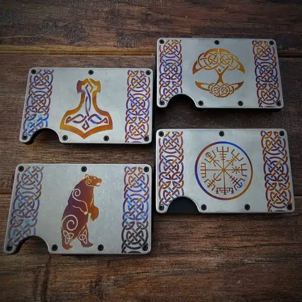 Four intricately designed metal plates with Norse inspired patterns are displayed on a wooden surface. The designs include symbols such as a hammer, a bear, and runic motifs.